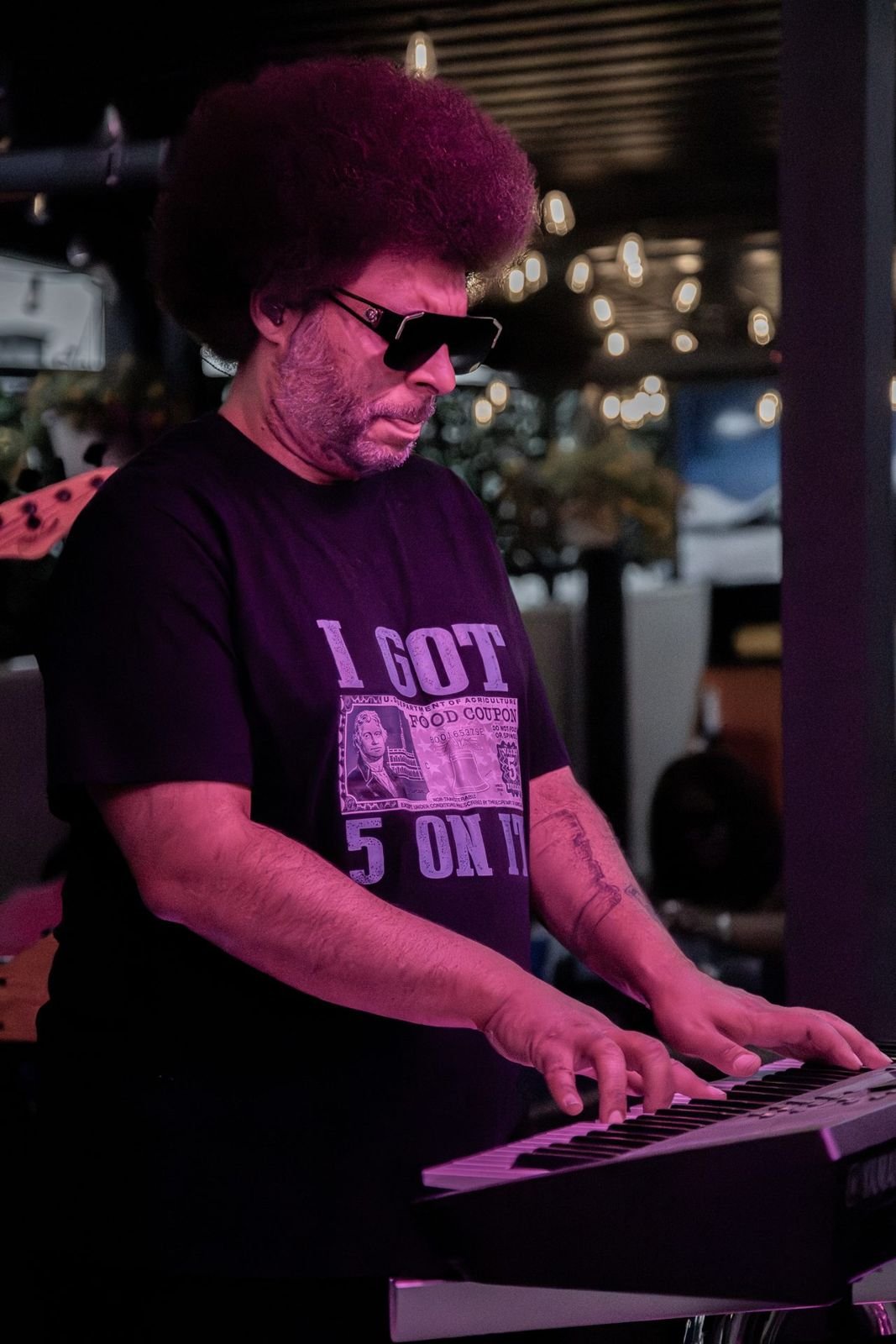 Little Moses Jones playing keys at an evening show